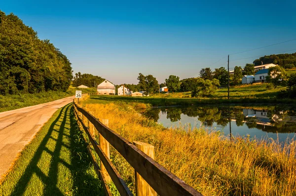 Lagoa e cerca ao longo de uma estrada rural no Condado de York, Pensilvânia — Fotografia de Stock