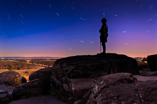 Star trails over boulders and statue on Little Round Top at nigh — Stock Photo, Image