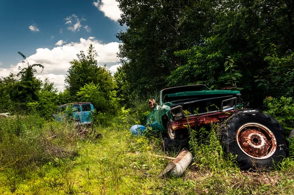 Oude van en vrachtwagen in een autokerkhof — Stockfoto