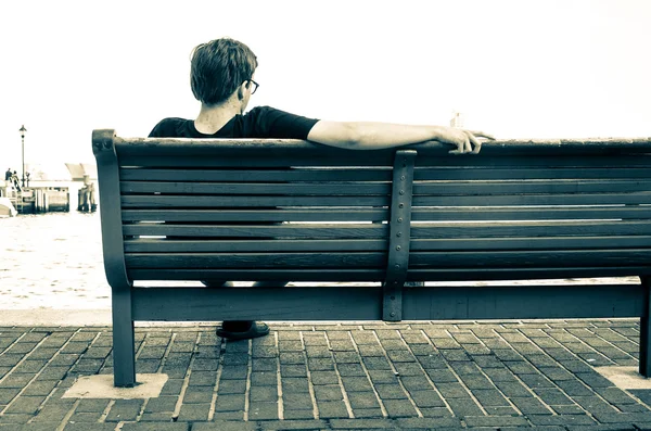 Homme assis sur un banc en bord de mer à Fells Point, Baltimore, Maryl — Photo