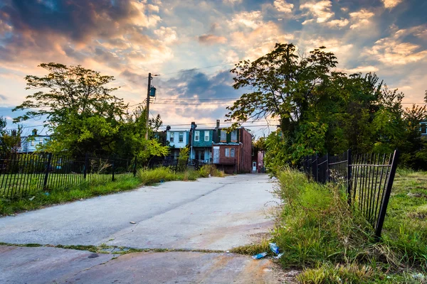 Sunset over a street and abandoned rowhouses in Baltimore, Maryl — Stock Photo, Image