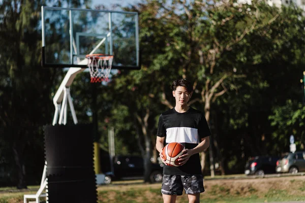 Αθλητισμός Και Ψυχαγωγία Έννοια Ένα Νεαρό Αρσενικό Παίκτη Μπάσκετ Κρατώντας — Φωτογραφία Αρχείου