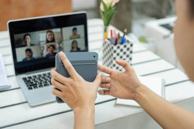 Çevrimiçi konsept üzerinde çalışan beyaz tişörtlü adam oldukça mutlu hissediyor ve hesap makinesini muhasebe sınıfında rakamları hesaplamak için tutuyor..