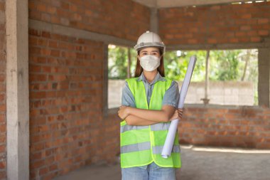 Mühendislik konsepti. Bina diyagramı olan kadın mühendis binanın detaylarına bakıyor..