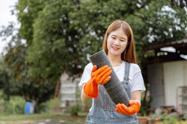 Kadın bahçıvan konsepti plastik tencere miktarı, kadın bahçıvanın ellerinde, toprak ve tohumlarla doldurulmaya hazır..
