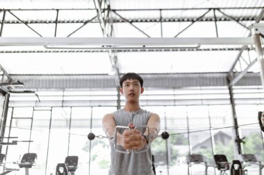 Egzersiz konsepti. Erkek kulüp abonesi ayakta duruyor ve iki eliyle ipi kendine doğru çekiyor..