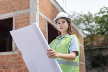 Mühendis konsepti. Beyaz maske takan ve miğfer takan kadın mühendis..