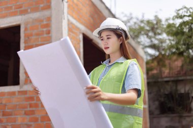Mühendis konsepti. Beyaz maske takan ve miğfer takan kadın mühendis..