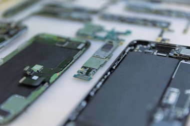 Telefon tamir konsepti. Parçalara ayrılan çeşitli elektronik cihazlar. Kapaklar, devre kartları, vücutlar gibi..