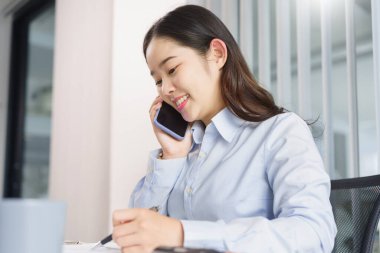 İş konsepti, iş kadınının belgelerle ilgili bilgileri kontrol etmek için ortaklarıyla telefonda konuşması.
