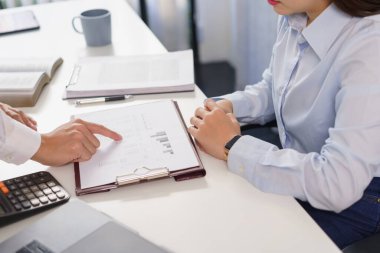 İş konsepti ve iş arkadaşı, ortaklara mali verileri açıklayan belgeye işaret ediyor.