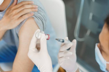 Aşı konsepti, erkek doktor erkek hastaya covid-19 aşısı hazırlıyor..