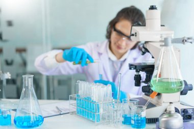 Laboratuvar araştırma konsepti, bilim adamı aşı ve ilaç araştırması için test tüpüne çözelti döker..