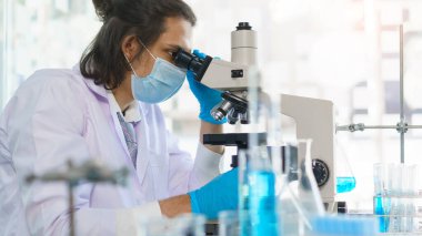 Laboratuvar araştırma konsepti, laboratuvarda mikroskopla ilaç ve aşı araştırması yapan bilim adamı..