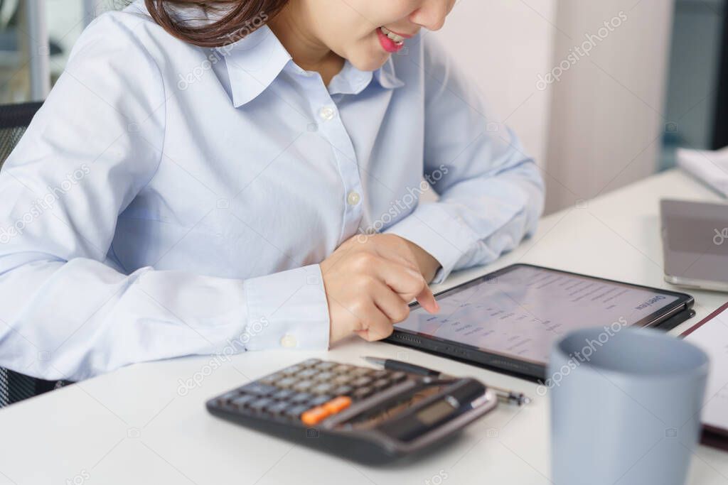 Business concept, Businesswoman in headset to listen music and checking financial report on tablet.