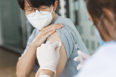 Aşı konsepti, erkek doktor erkek hastaya covid-19 aşısı hazırlıyor..