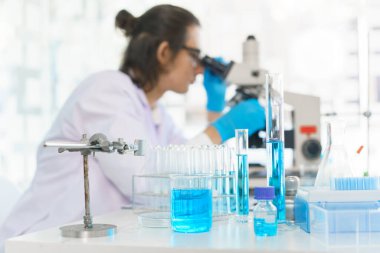 Laboratuvar araştırma konsepti. Bilim adamı aşıyı geliştirmek ve araştırmak için mikroskop kullanıyor..