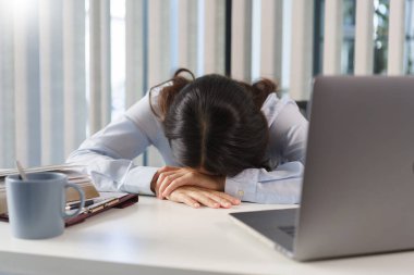 İş konsepti, iş kadını teneffüste uyuyan ofis masasında sıkı çalışmaktan..