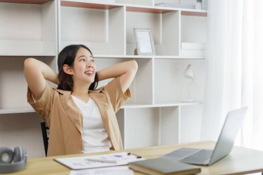 Çevrimiçi yaşam tarzı konsepti. Bir kadın çalışan rahatça bir online proje yaptıktan sonra kollarını dinlendiriyor.