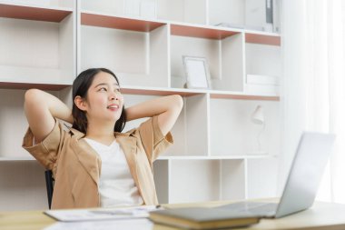 Çevrimiçi yaşam tarzı konsepti. Bir kadın çalışan rahatça bir online proje yaptıktan sonra kollarını dinlendiriyor.