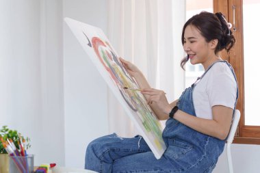 Sanat yaratıcılığı, genç Asyalı kadın resim çizmek için stüdyoda oturuyor..