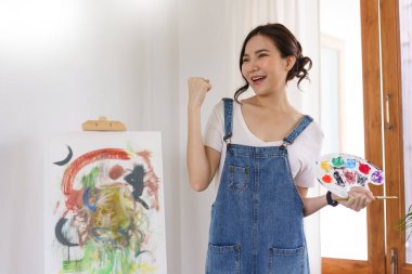 Sanat konsepti. Genç Asyalı kadın sanat şaheserlerini çizdikten sonra mutlu..