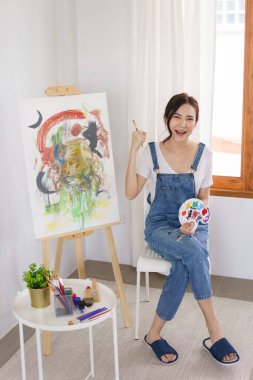 Sanat konsepti. Genç Asyalı kadın sanat şaheserlerini çizdikten sonra mutlu..