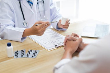 Bir doktor konseptini ziyaret ediyorum. Bir hastaya tedavi için beyaz şişedeki hapın nasıl içileceği öneriliyor.