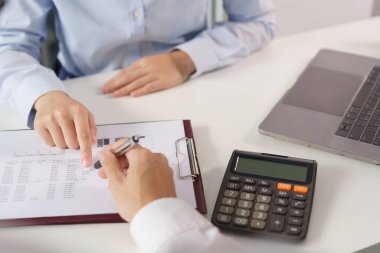 İş konsepti: İki iş arkadaşı projedeki yatırımı açıklayan belgeye işaret ediyor.