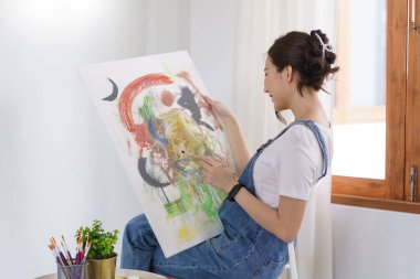 Sanat yaratıcılığı, genç Asyalı kadın resim çizmek için stüdyoda oturuyor..