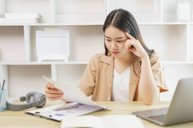 Çevrimiçi yaşam tarzı konsepti. Bir kadın ev işçisi ciddi şekilde gazeteden bazı verileri okumaya odaklanıyor. 