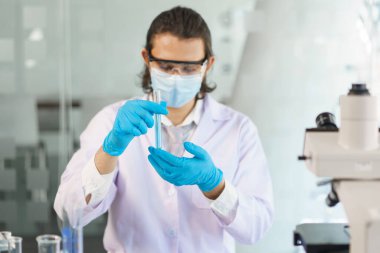 Laboratuvar araştırma konsepti, bilim adamı test tüpündeki numuneyi ilaç ve aşı geliştirmek için analiz ediyor..