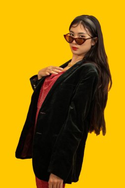 Fashion concept, Fashionable woman wear sunglasses to posing in red dress with oversize black coat.