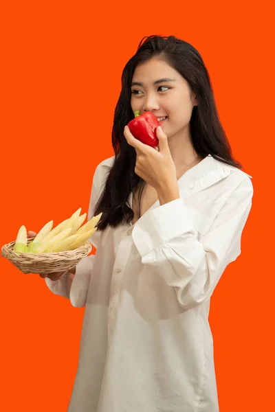 素食主义者的概念 健康的女人吃红椒 带着橙子背景的玉米 — 图库照片