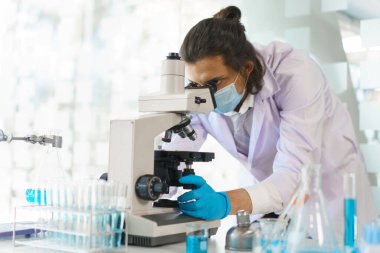 Laboratuvar araştırma konsepti, laboratuvarda mikroskopla ilaç ve aşı araştırması yapan bilim adamı..