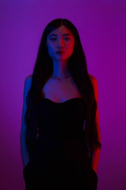 Moda ve güzellik anlayışı, parlak makyajlı moda kadını neon ışıklı arka planda poz veriyor..