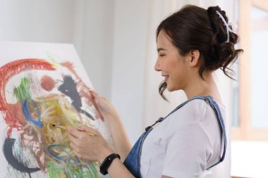 Sanat yaratıcılığı, genç Asyalı kadın resim çizmek için stüdyoda oturuyor..