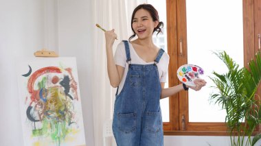 Sanat konsepti. Genç Asyalı kadın sanat şaheserlerini çizdikten sonra mutlu..