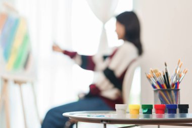 Sanat konsepti, Asyalı kadın ressamın tuvale oranını ölçtüğünde ekipman çizmeye odaklan.