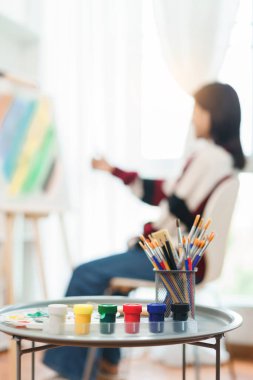 Sanat konsepti, Asyalı kadın ressamın tuvale oranını ölçtüğünde ekipman çizmeye odaklan.