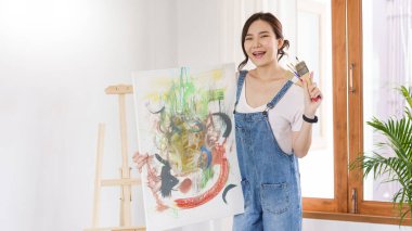 Sanat konsepti, genç Asyalı kadın sanat eseri ve boya fırçası tutuyor..