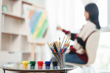 Sanat konsepti, Asyalı kadın ressamın tuvale oranını ölçtüğünde ekipman çizmeye odaklan.