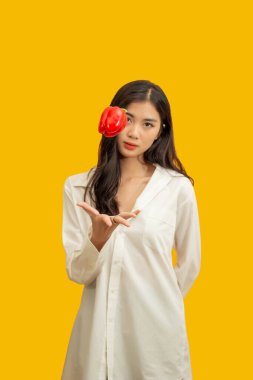 Vejetaryen konsepti, sağlıklı kadın izole edilmiş sarı arka planda renkli dolma biber kusuyor..