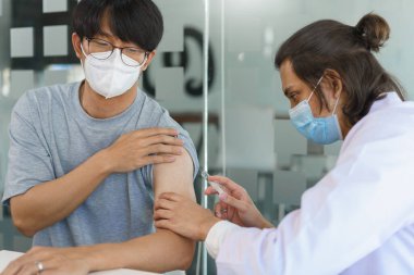 Aşı konsepti, maske takan erkek doktor erkek hasta için covid-19 aşısı yapıyor..
