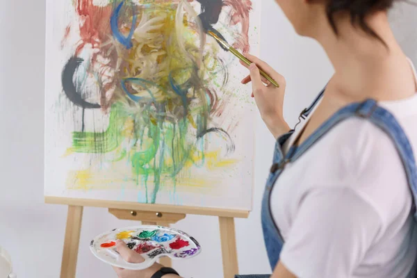 Creative of art concept, Young asian woman using paintbrush to painting art masterpiece in studio.
