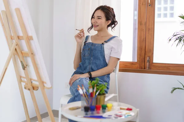 Creative Art Concept Young Asian Woman Holding Paintbrush Contemplate Artwork — стоковое фото