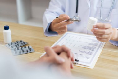 Bir doktor konseptini ziyaret ediyorum. Bir hastaya tedavi için beyaz şişedeki hapın nasıl içileceği öneriliyor.