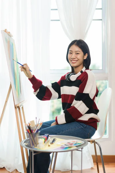 Koncepcja Sztuki Azjatycka Artystka Swetrze Słuchawką Malowania Płótnie Pracowni Artystycznej — Zdjęcie stockowe