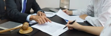 Avukat danışmanlığı kavramı, kıdemli avukat ayrıntıları açıkladıktan sonra boşanma sözleşmesi imzalayan çift..