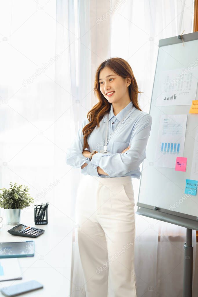 Successful business concept, Businesswoman are smiling and standing with crossed arms in office.